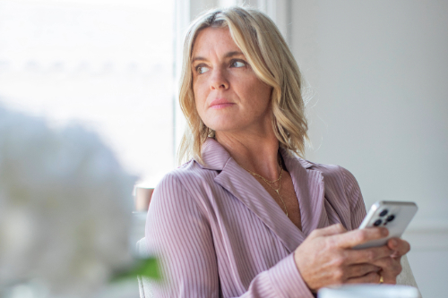 A person holding a phone and looking up