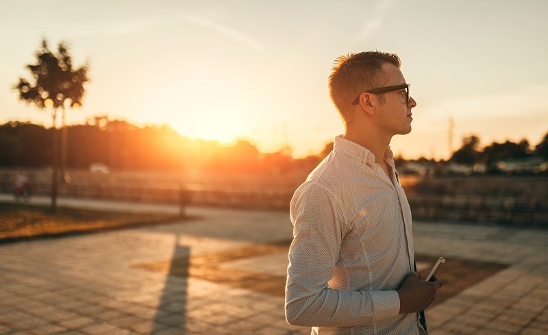 A person holding a tablet and looking away