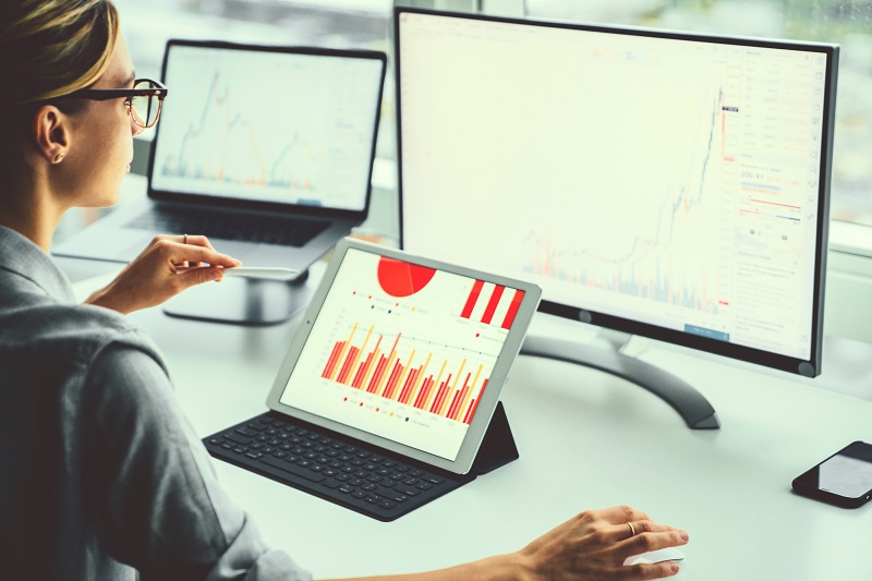 A woman looking at multiple monitors