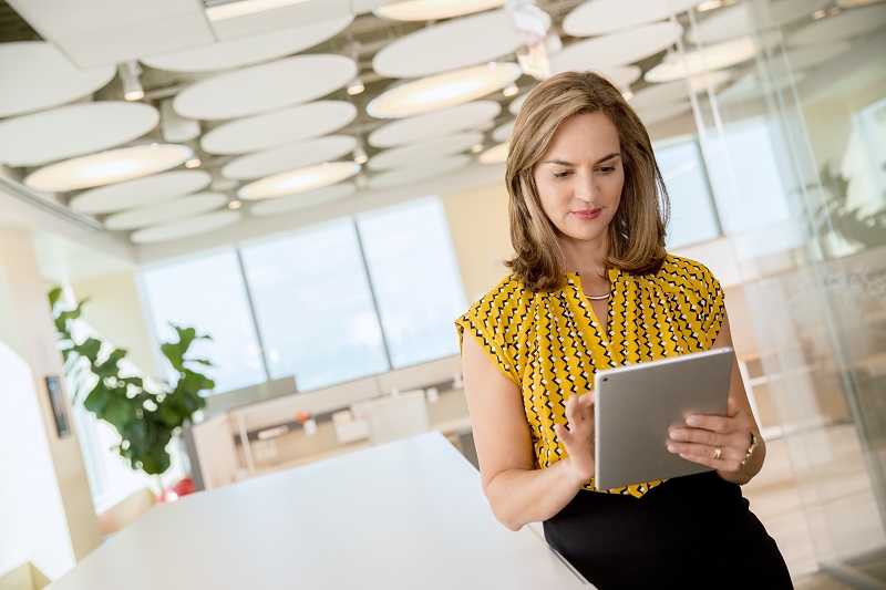 Woman in modern office holding digital tablet