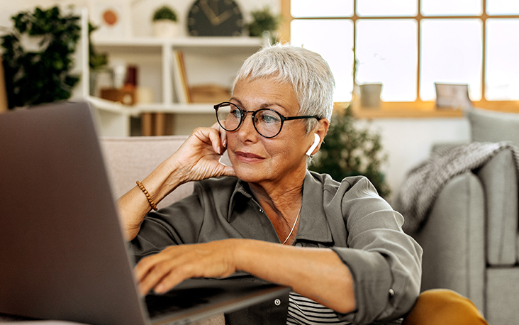 Mature woman looking at laptop, keeping her passwords safe