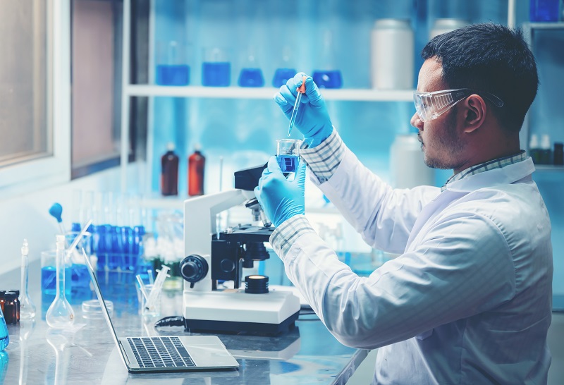 Chemist in laboratory surrounded by equipment