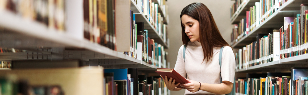 Woman in book stacks at library